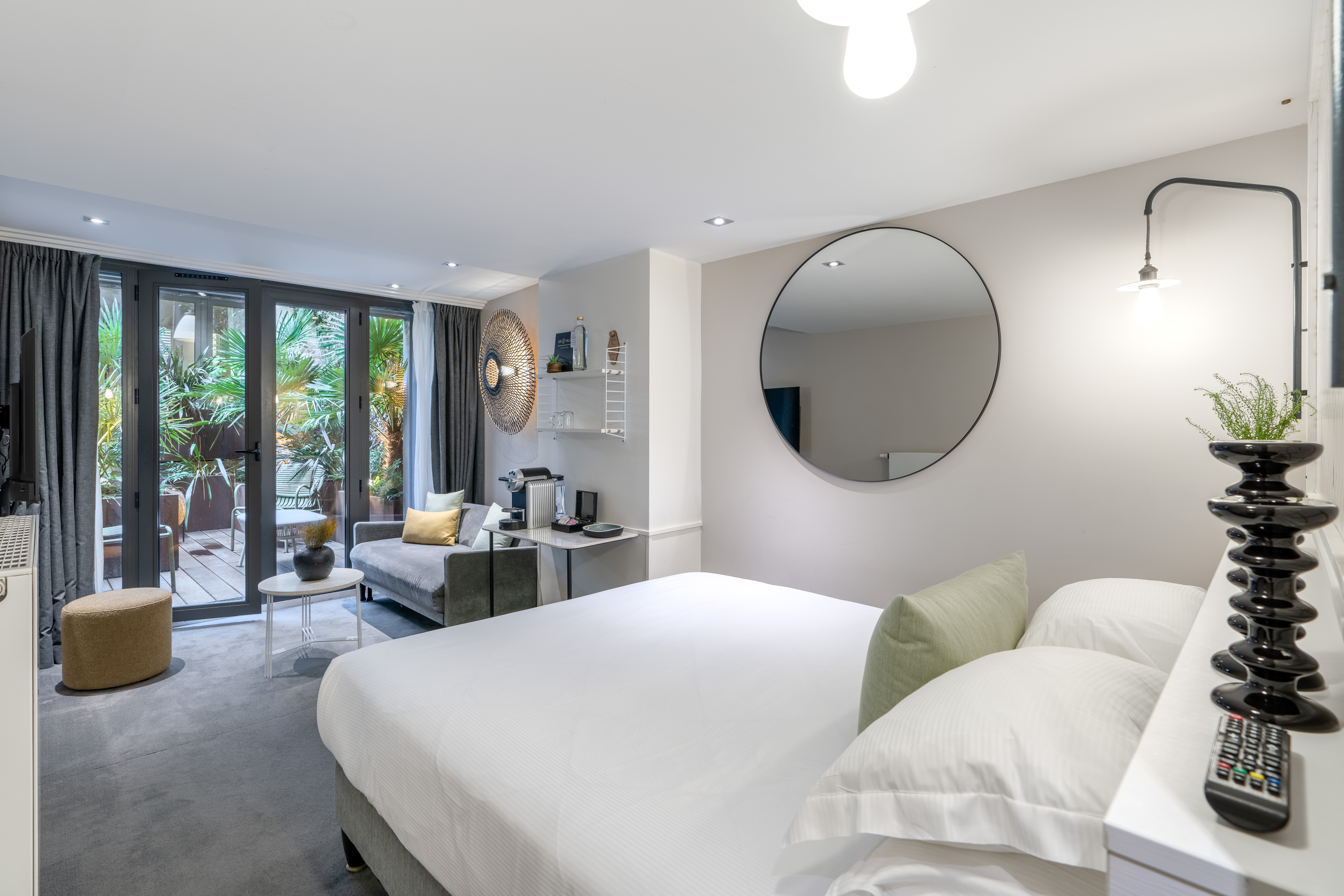 Décorée avec chic et élégance, un confortable salon avec canapé offre une vue reposante sur le patio.
